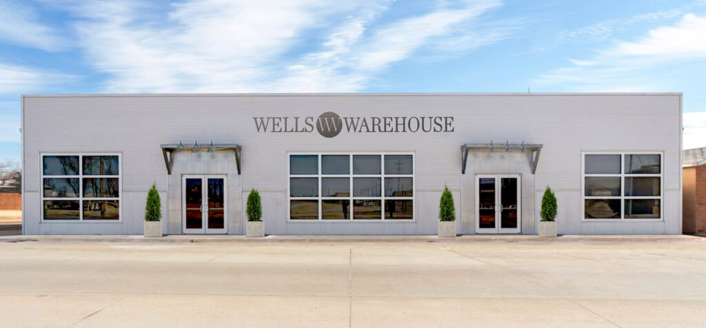 exterior of an industrial metal building with a sign that reads Wells Warehouse